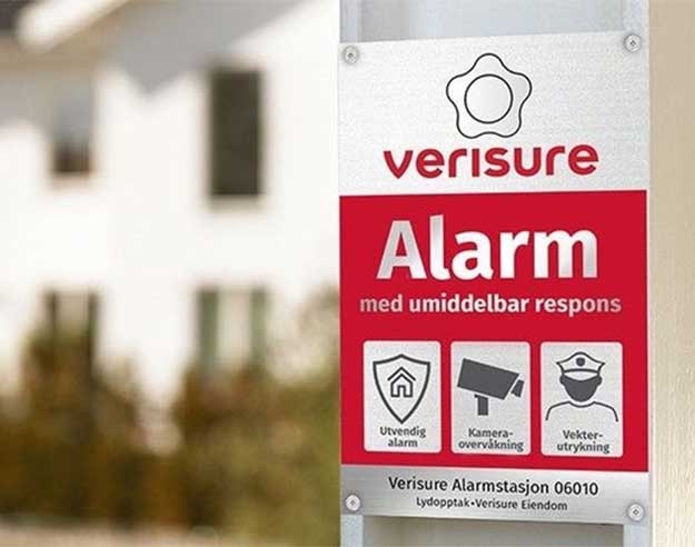 Ekte alarmskilt på stolpe foran hus