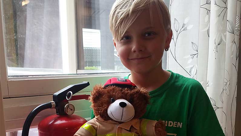 Robin med bamsen han fikk for vellykket brannslukking