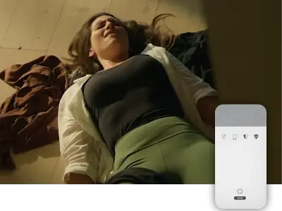 Dame ligger på gulvet med smerter og betjeningspanel