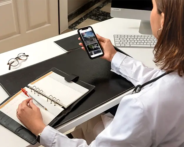 Dame sjekker boligen via kamera