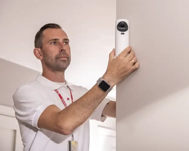 Sikkerhetsekspert installerer verisure kameradetektor i salong