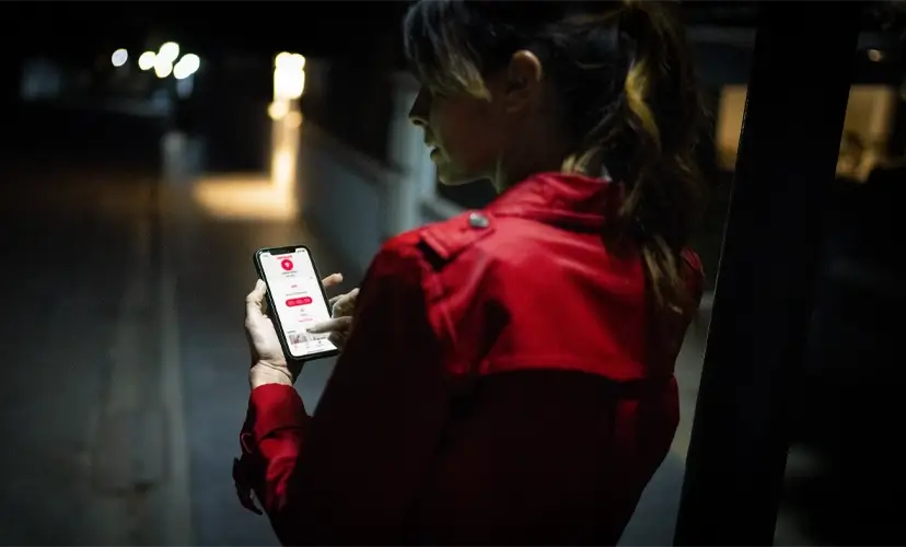 Dame trykker på Verisure app i mørket Dame trykker på Verisure app i mørket
