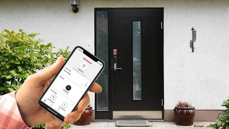 Mann styrer alarm og dørlås via fjernstyring i app