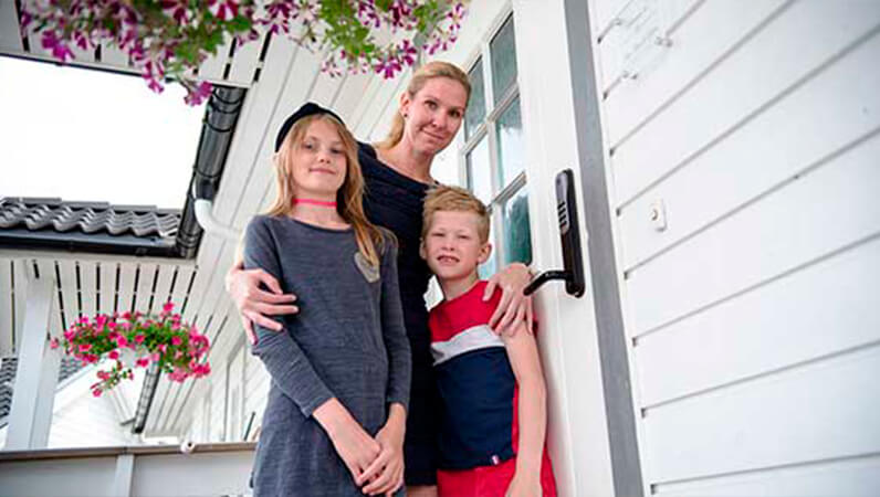 Familie foran dør med alarm og dørlås