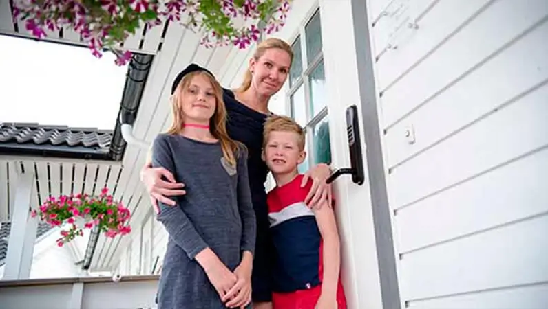 Familie foran dør med alarm og dørlås