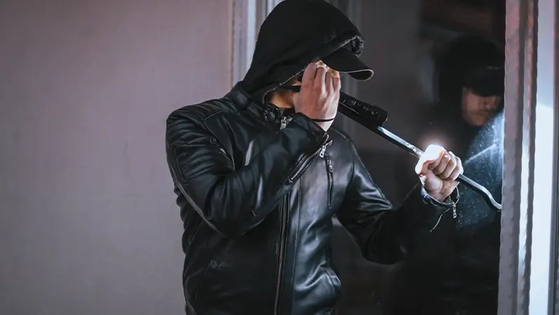 Innbruddstyv prøver å bryte opp vindu