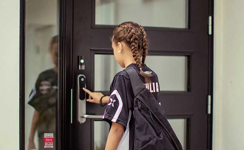 Jente kommer hjem fra skolen til alarmsikret hus