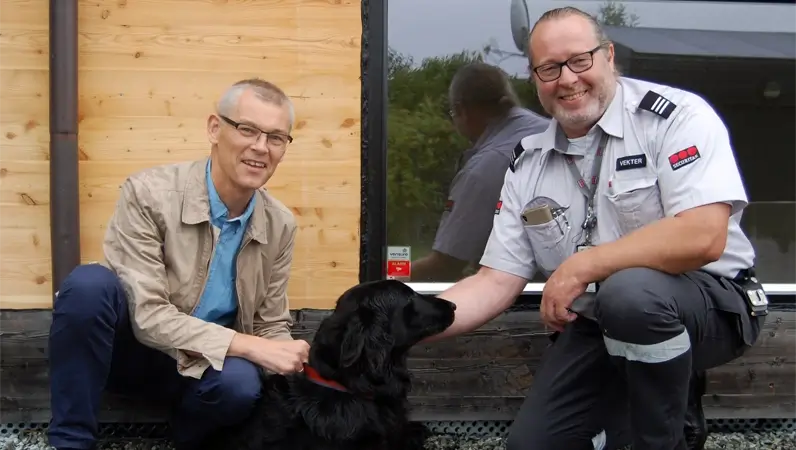 Vekter, huseier og hund foran hus sikret med Verisure alarm