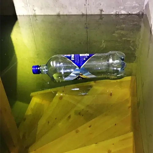 Flaske flyter på vannet ned til kjelleren Flaske flyter på vannet ned til kjelleren