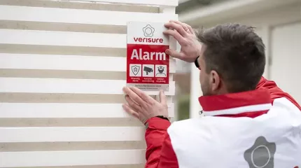 Montør installerer alarmskilt Montør installerer alarmskilt