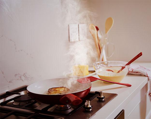 Frying pan on oven with smoke