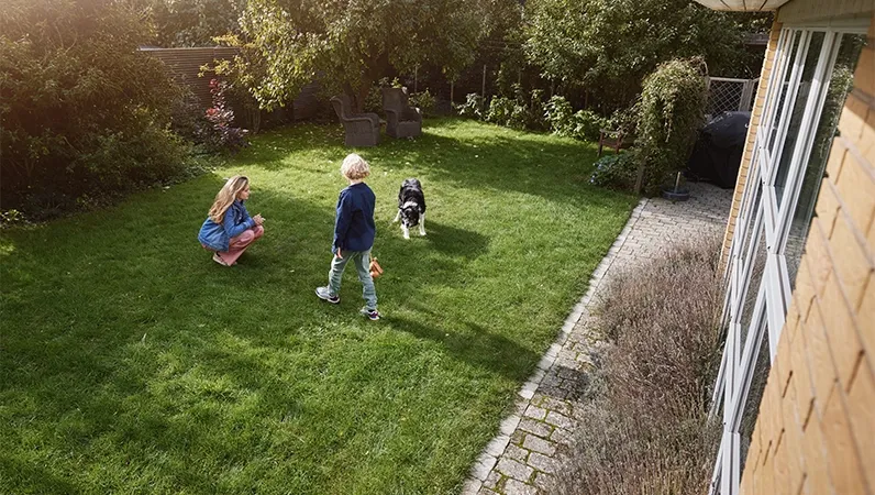 Søsken som leker i hagen