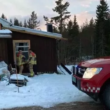 Brannmenn og brannbil ved hus