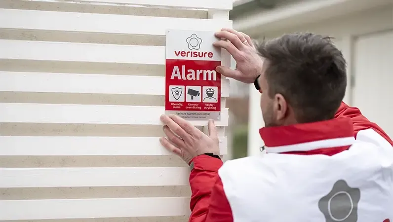 Installatør monterer alarmskilt