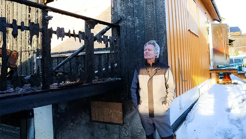 Torbjørn foran nedbrent hus